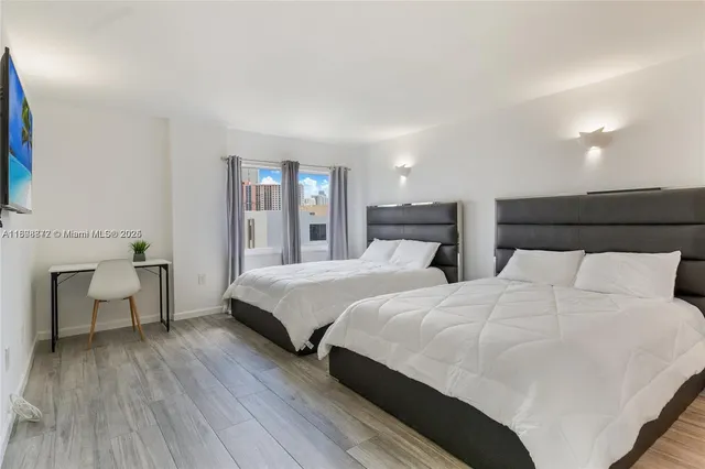 a bedroom with two beds and painting on the wall