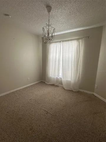 en empty room with windows and ceiling fan