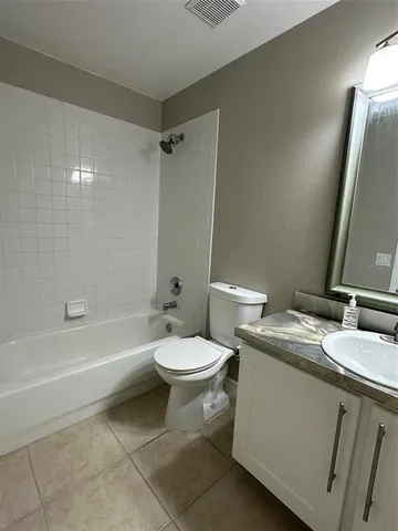 a bathroom with a granite countertop toilet sink and mirror
