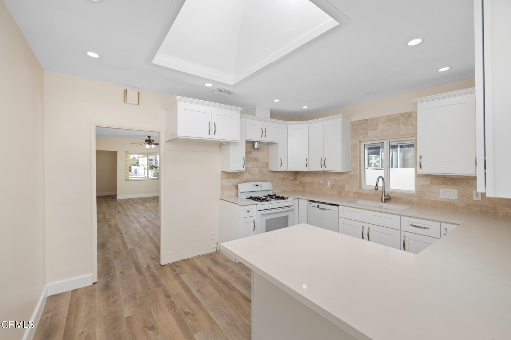 4516 Earle Avenue Rosemead, CA 91770 - Photo 7 of 23 a kitchen with a sink a stove a refrigerator and white cabinets