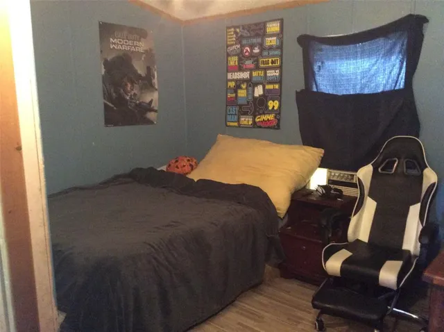 a bedroom with a bed and wooden floor