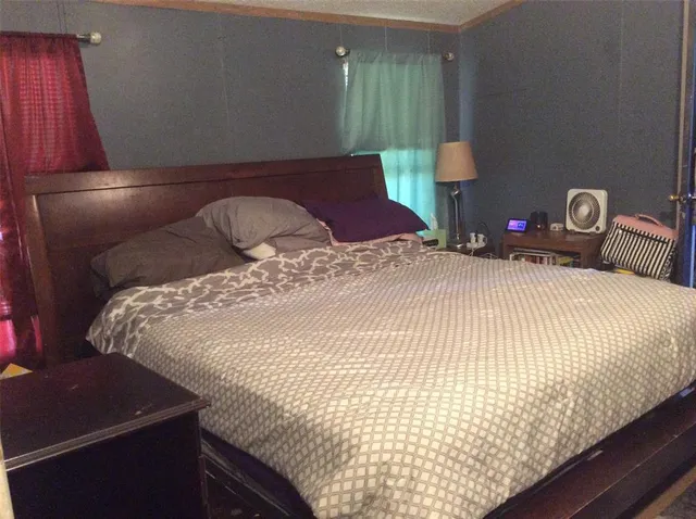 a bed sitting in a bedroom next to a window