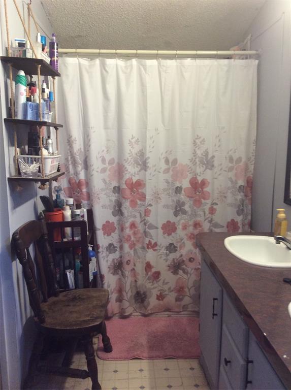 8762 Private Road 4641 Baird, TX 79504 - Photo 18 of 36 a bathroom with a granite countertop sink and a mirror