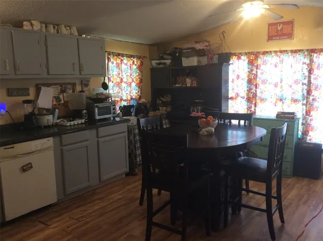 a kitchen with a table chairs white cabinets and wooden floor