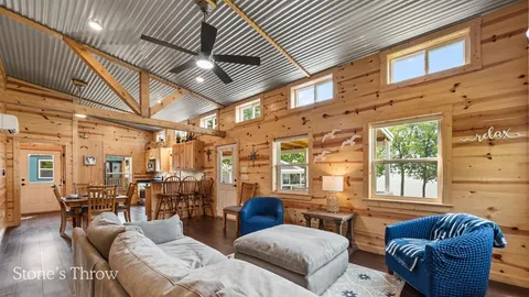 a bedroom with a bed a desk and chair with the wooden floor
