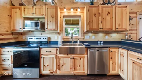 a bedroom with a bed a desk and chair with wooden floor