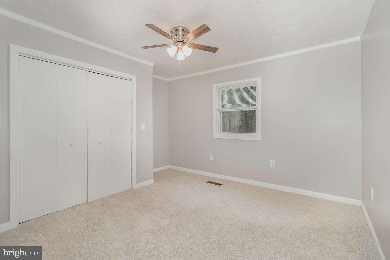475 Company Farm Road Aspers, PA 17304 - Photo 17 of 45 an empty room with a chandelier fan and windows