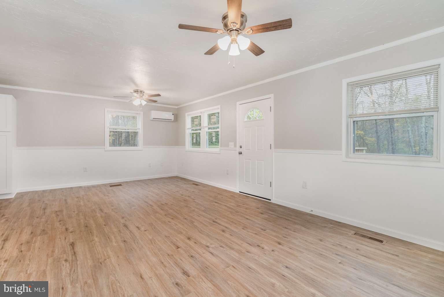 475 Company Farm Road Aspers, PA 17304 - Photo 8 of 45 an empty room with wooden floor fan and windows