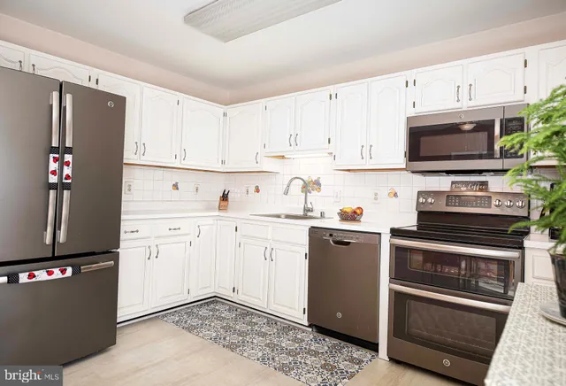 a kitchen with stainless steel appliances granite countertop a refrigerator sink and stove