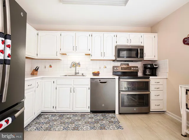 a kitchen with cabinets stainless steel appliances and a counter space