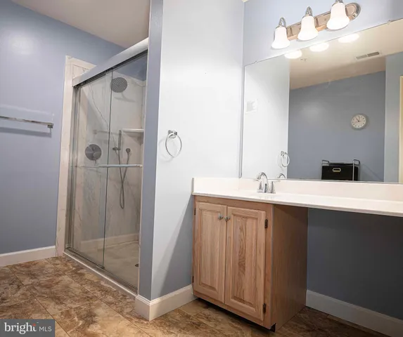 a bathroom with a double vanity sink mirror and shower