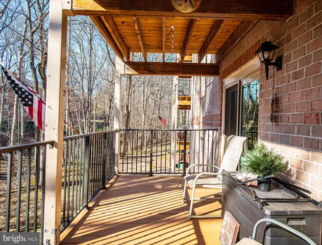 a view of a porch with wooden floor and iron fence