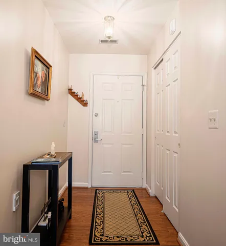 a view of a hallway with closet and wooden floor