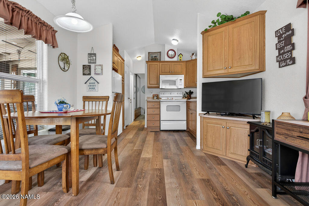 17550 South Munds Ranch Road, Unit 343 Munds Park, AZ 86017 - Photo 13 of 31 a kitchen with stainless steel appliances granite countertop a stove top oven a refrigerator a dining table and chairs with wooden floor