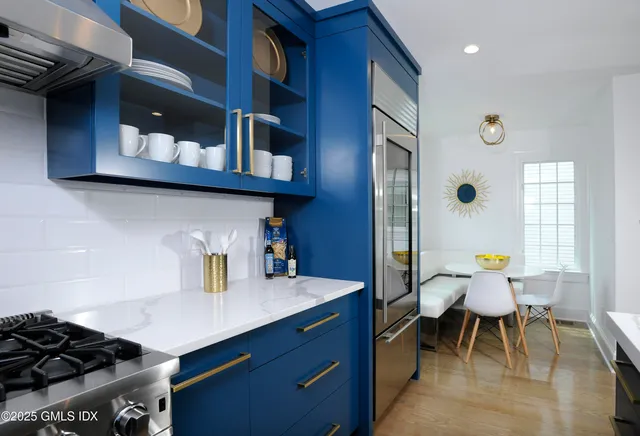 a kitchen with stainless steel appliances granite countertop a stove and a dining table