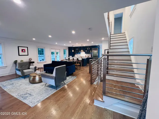 a living room with couches and kitchen view with wooden floor