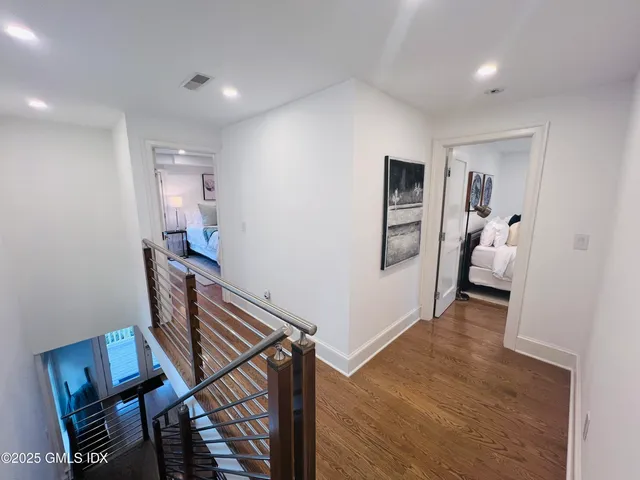 a bedroom with a bed window and wooden floor