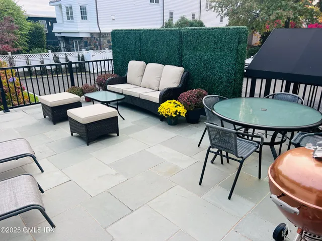 a view of a patio with couches and a fire pit and a yard