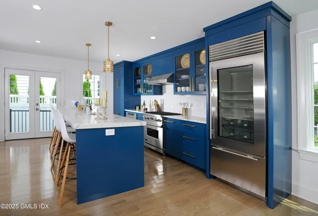 a kitchen with stainless steel appliances granite countertop a stove a refrigerator and a view of living room