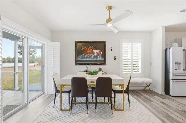 a view of a dining room with furniture a chandelier and wooden floor