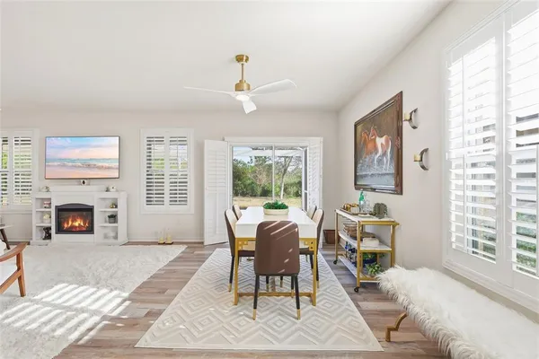 a living room with furniture a fireplace and a large window