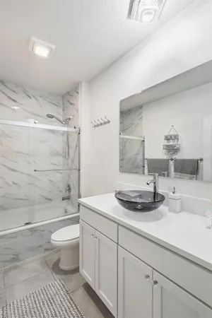 a bathroom with a sink a toilet and shower