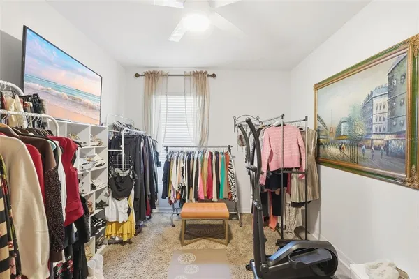 a view of walk in closet with clothes