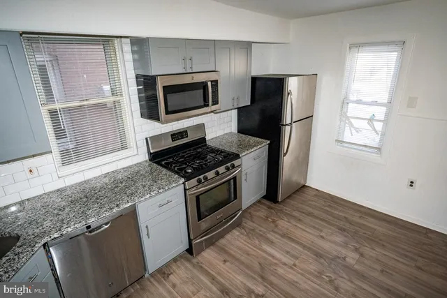 a kitchen with granite countertop a stove and a microwave