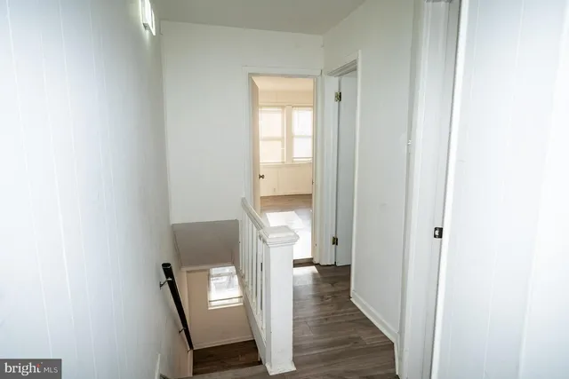 a view of a hallway with wooden floor and entryway