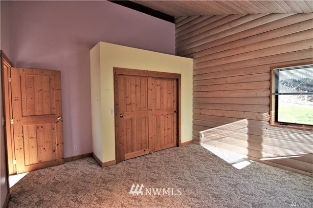 1072 Dabob Road Quilcene, WA 98376 - Photo 13 of 25 a view of a house with a door and wooden walls