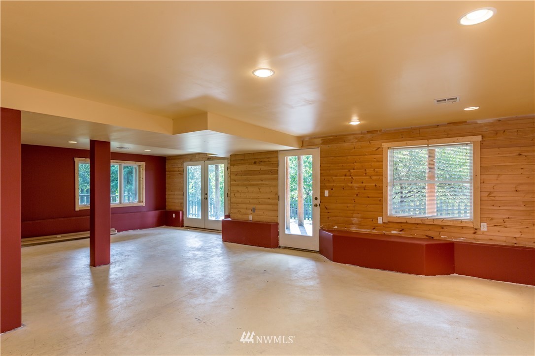 1072 Dabob Road Quilcene, WA 98376 - Photo 17 of 25 an empty room with large windows and a chandelier