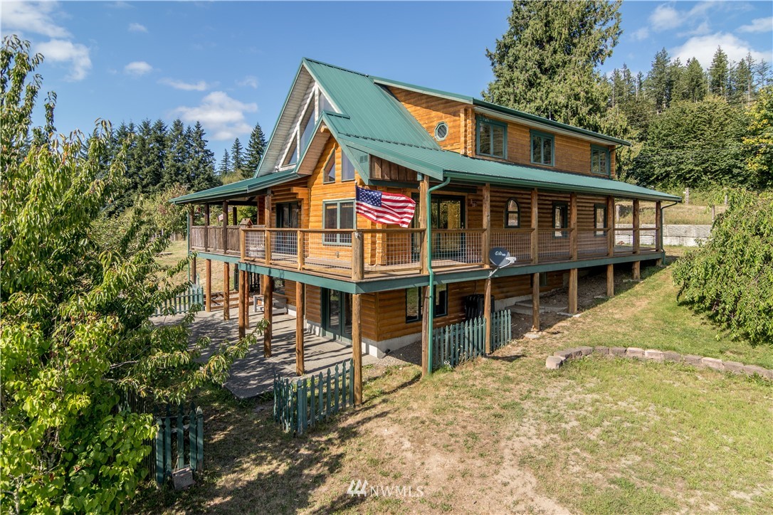 1072 Dabob Road Quilcene, WA 98376 - Photo 3 of 25 a front view of a house with a garden