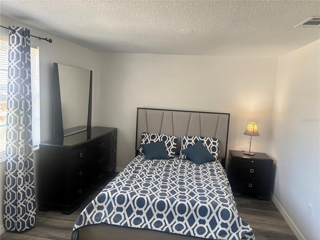 8302 Split Rail Lane Hudson, FL 34667 - Photo 14 of 21 a bedroom with a large bed and a mirror