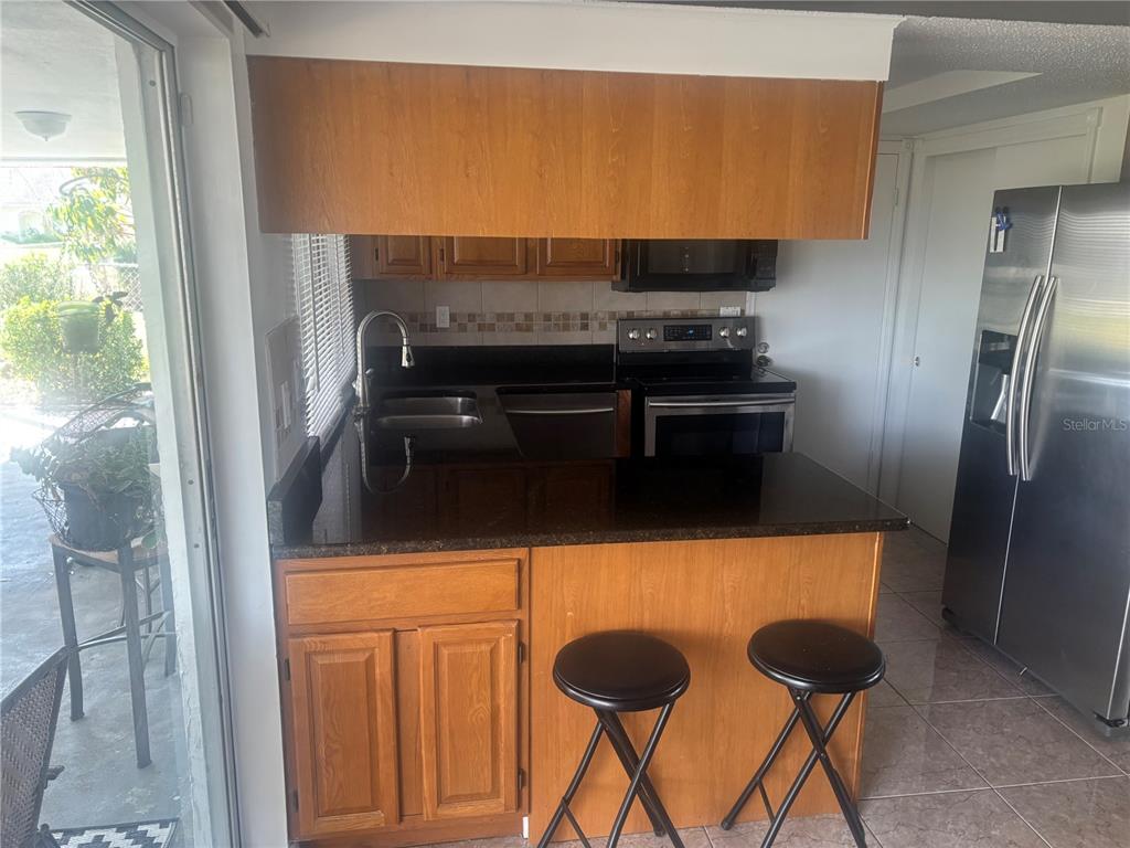 8302 Split Rail Lane Hudson, FL 34667 - Photo 5 of 21 a kitchen with stainless steel appliances a refrigerator and a stove
