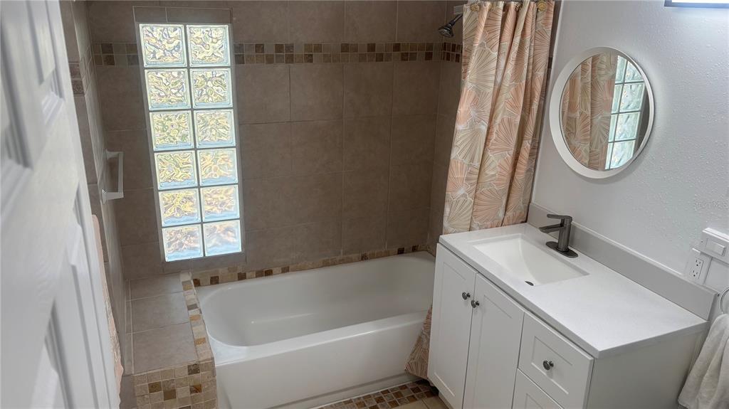 8302 Split Rail Lane Hudson, FL 34667 - Photo 10 of 21 a bathroom with a sink a bathtub and a window
