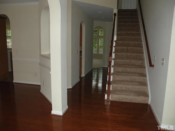 a view of entryway and hall with wooden floor