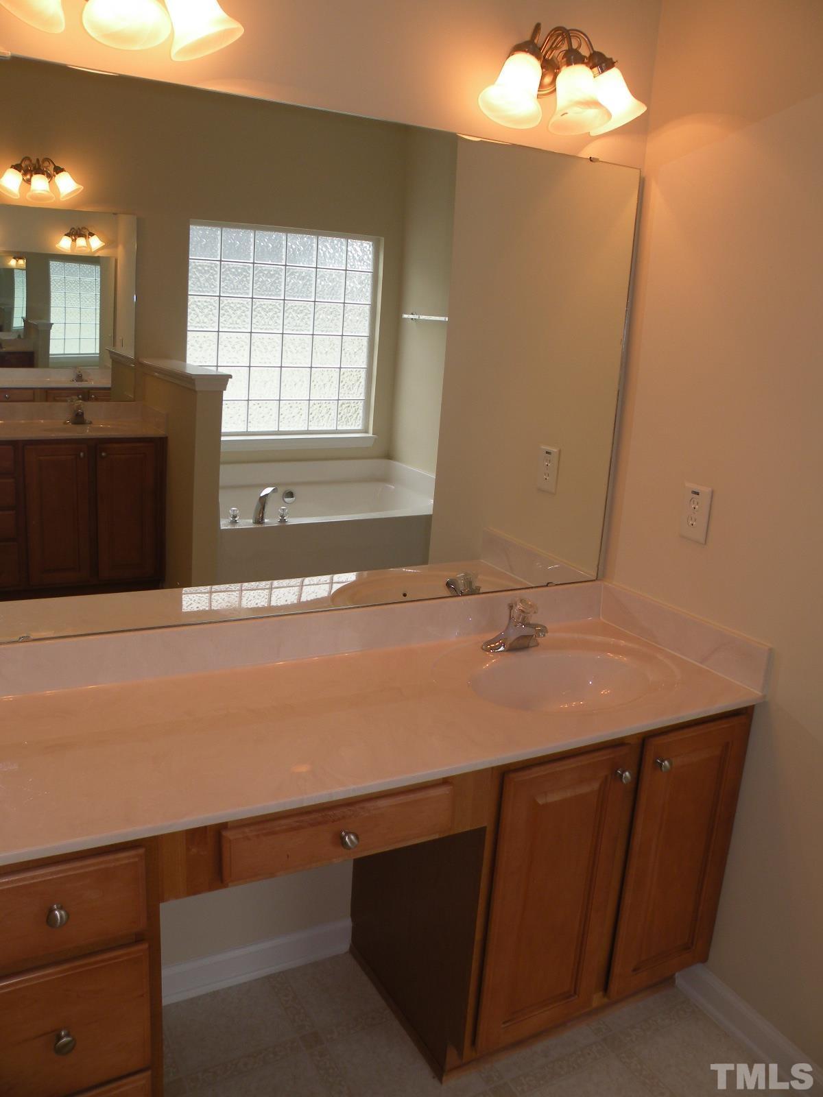4733 Porchaven Lane Apex, NC 27539 - Photo 16 of 25 a bathroom with a sink and a mirror