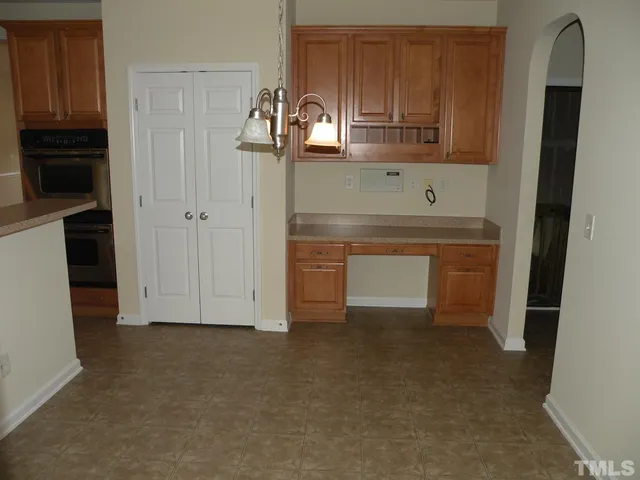 a view of kitchen with refrigerator and cabinets