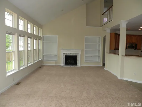 a view of an empty room with a fireplace and a window