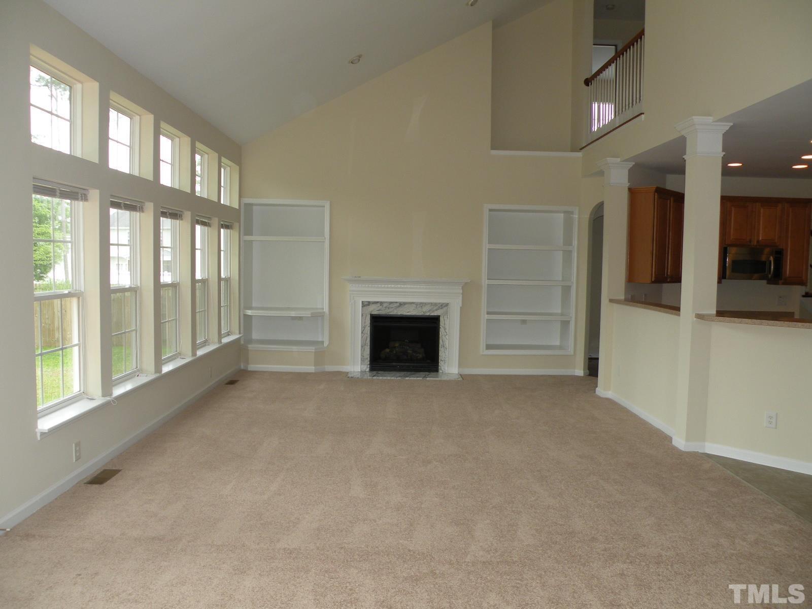 4733 Porchaven Lane Apex, NC 27539 - Photo 9 of 25 a view of an empty room with a fireplace and a window