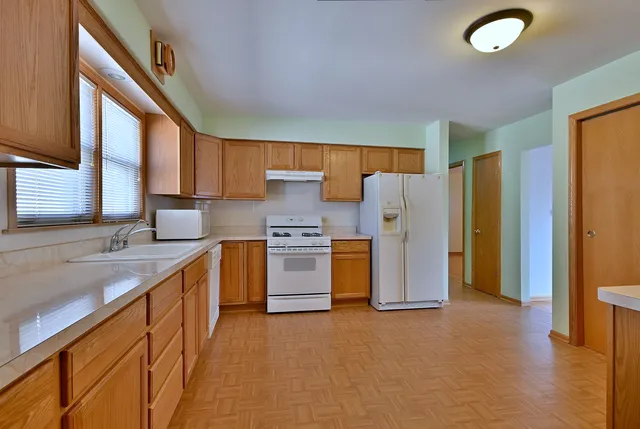 a kitchen with refrigerator a sink and cabinets