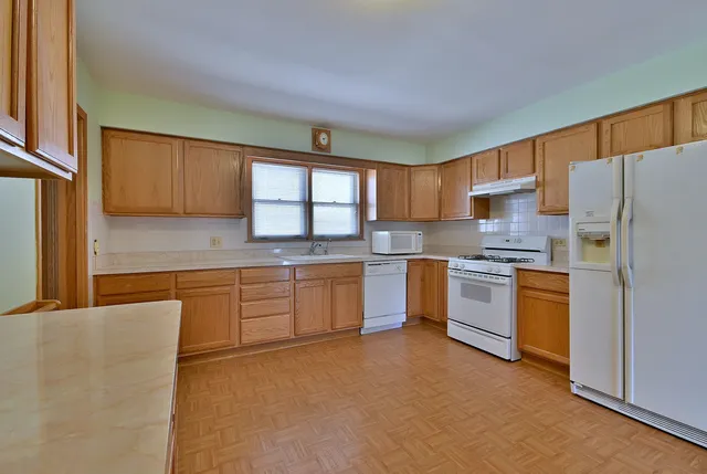 a kitchen with a refrigerator stove top oven and sink