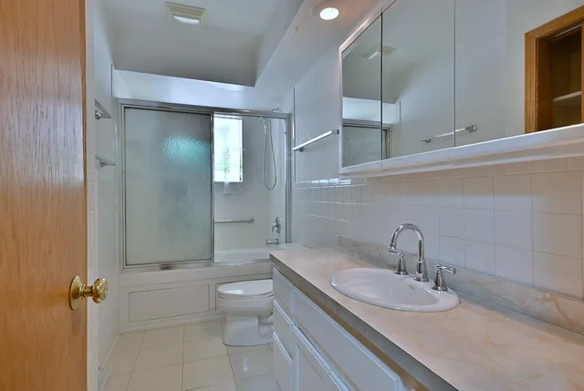 a bathroom with a sink and mirror with toilet