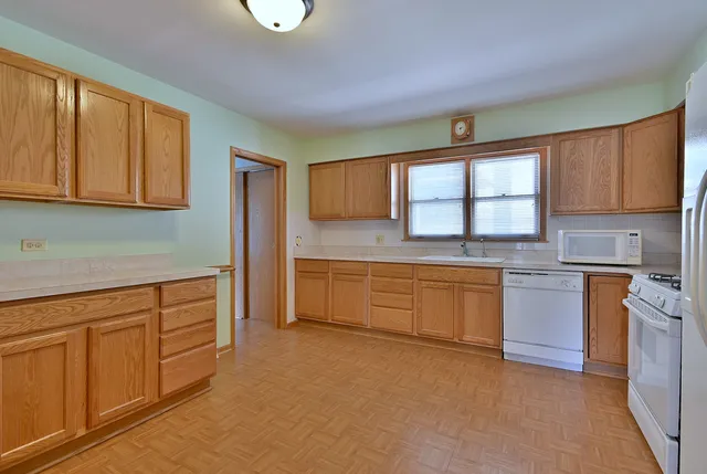 a kitchen with granite countertop white cabinets and white appliances