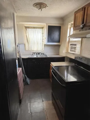 a kitchen with a sink stove and cabinets