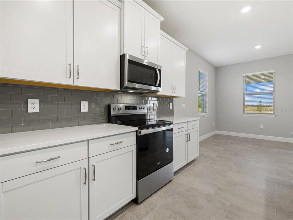 17707 Gulf Rnch Place Bradenton, FL 34211 - Photo 11 of 27 a kitchen with stainless steel appliances white cabinets and a sink