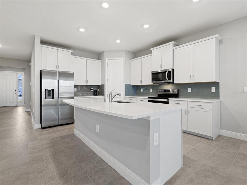 17707 Gulf Rnch Place Bradenton, FL 34211 - Photo 14 of 27 a kitchen with granite countertop white cabinets and stainless steel appliances