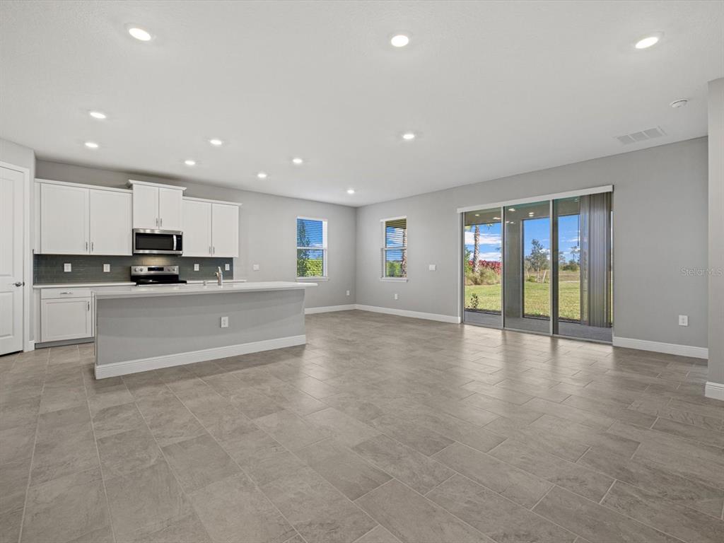 17707 Gulf Rnch Place Bradenton, FL 34211 - Photo 16 of 27 a large kitchen with stainless steel appliances granite countertop a large counter top and a stove with wooden floor