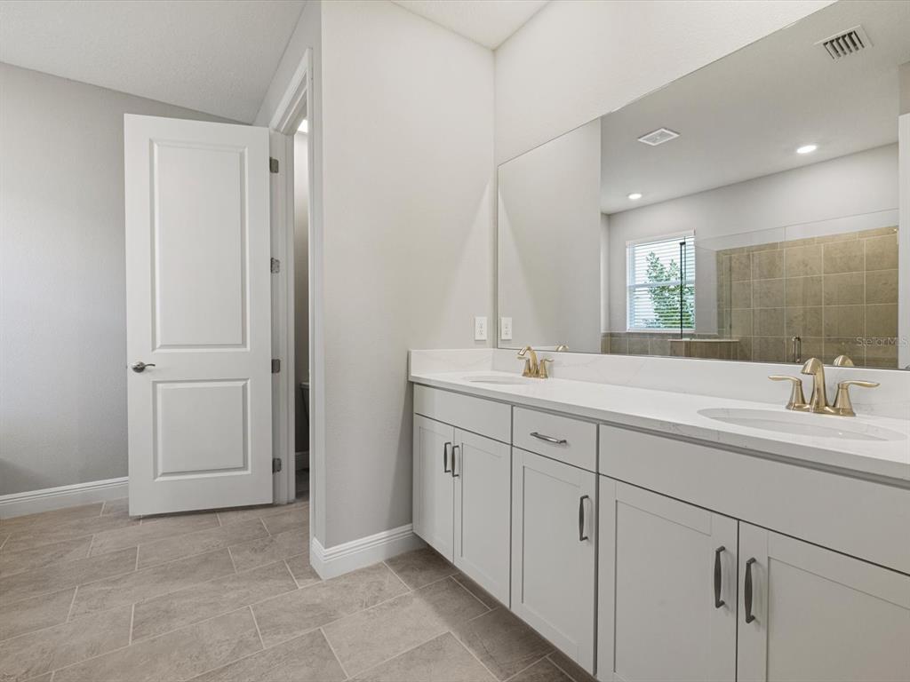17707 Gulf Rnch Place Bradenton, FL 34211 - Photo 17 of 27 a bathroom with a double vanity sink and a mirror