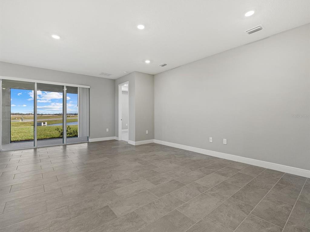 17707 Gulf Rnch Place Bradenton, FL 34211 - Photo 8 of 27 an empty room with sliding glass door and door